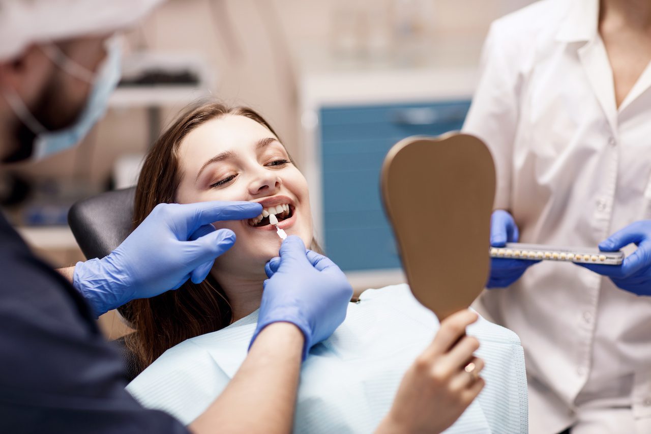 Dentist showing women patient teeth bleaching treatments