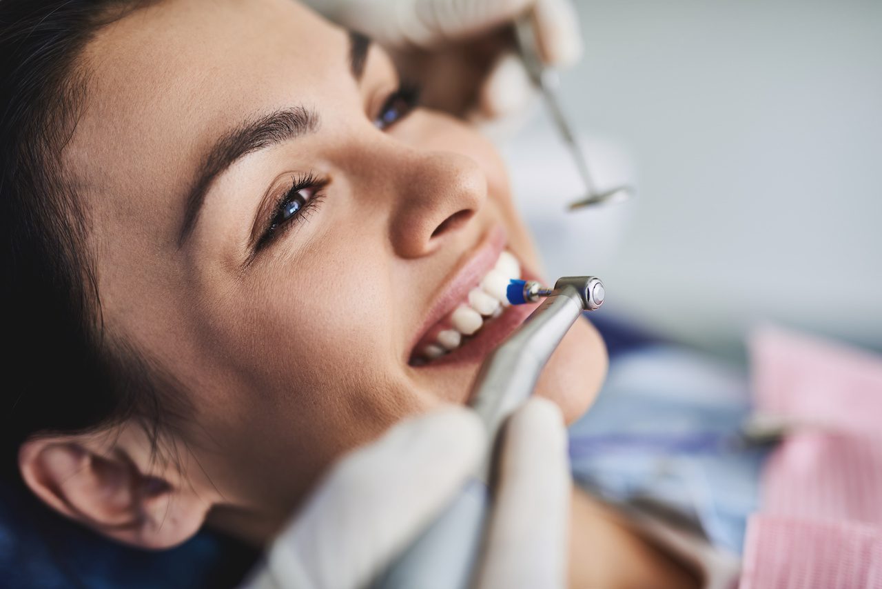 Dentist cleaning and polishing womens teeth