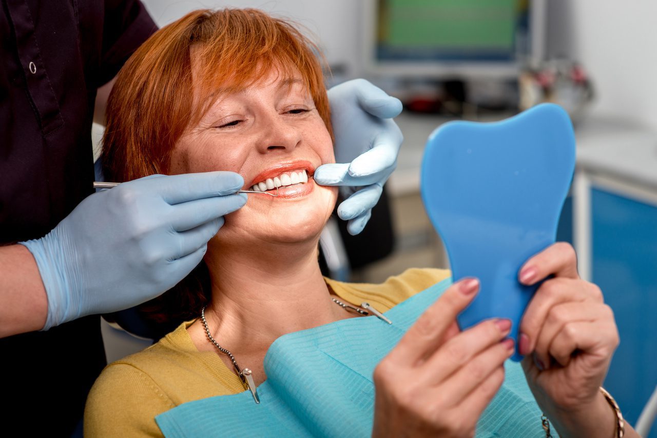 dentist showing women patient her new dental implants