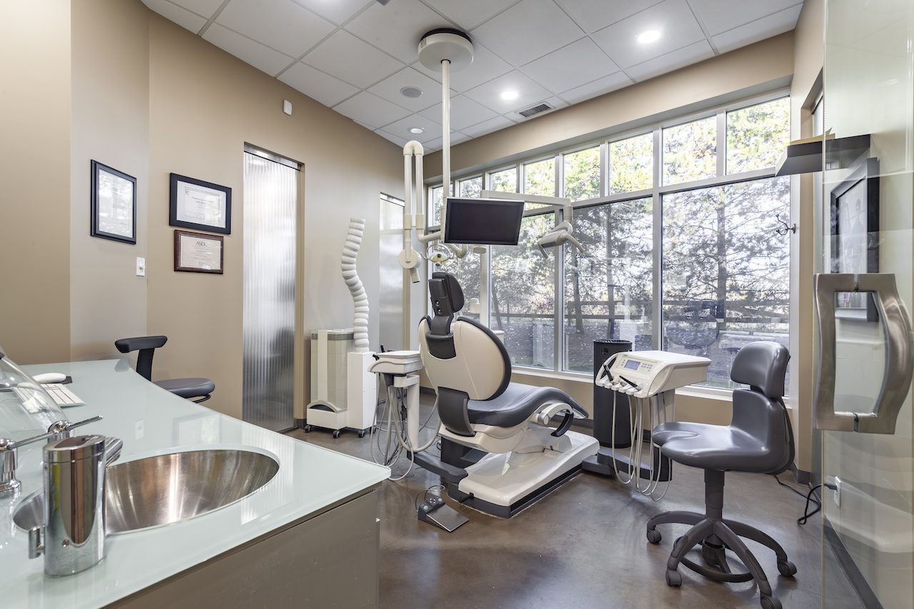Empty dental clinic room with chair looking out large window